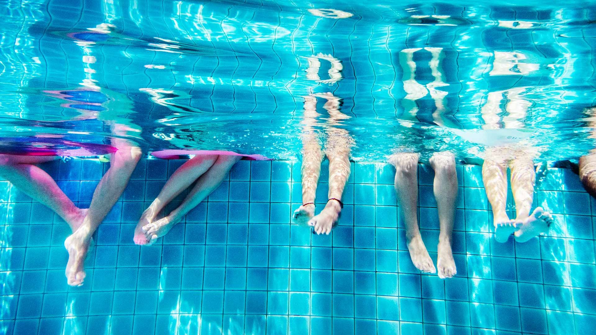 Vue sur des pieds trempants dans l'eau d'une piscine