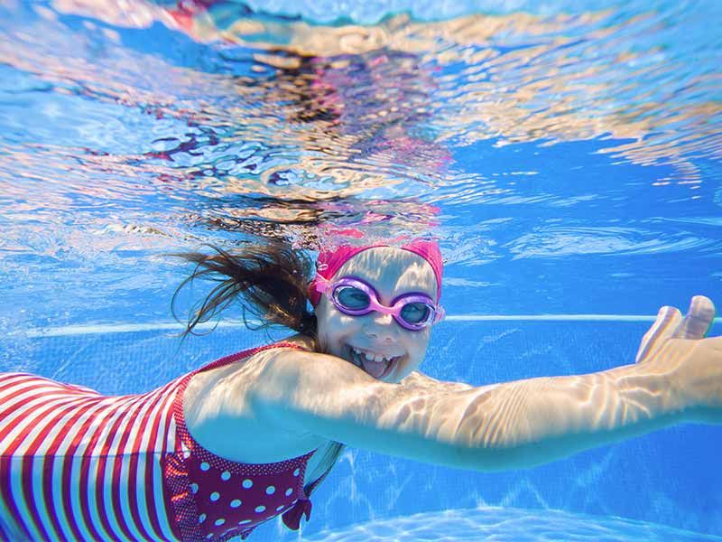 Fillette nageant sous l'eau en souriant