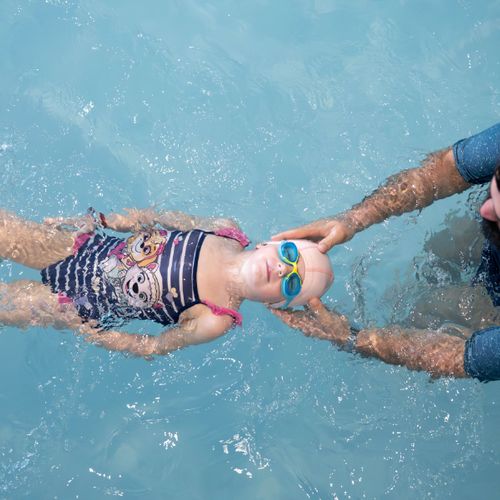 Fillette nageant sous l'eau en souriant