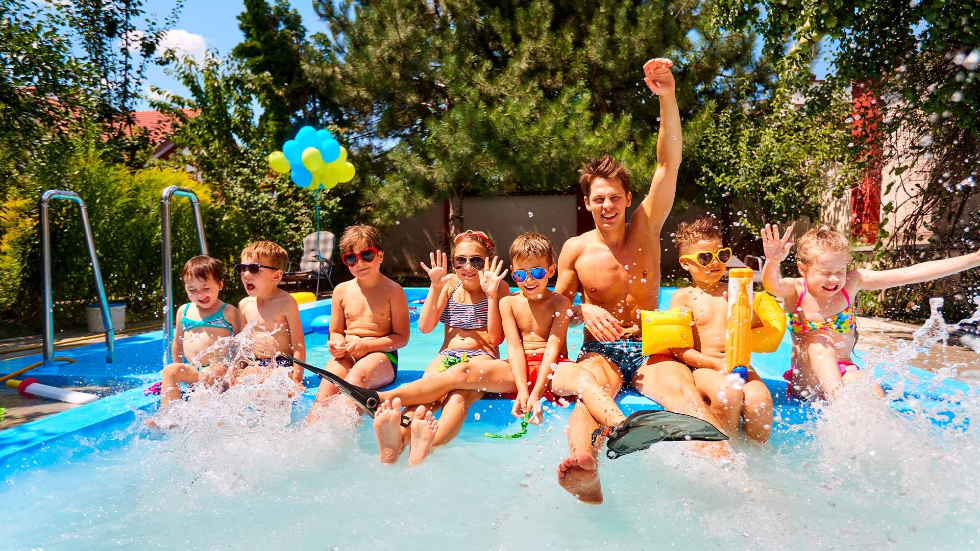 Groupe de jeunes gens assis sur une bouée et s'amusant dans une piscine lors d'un anniversaire