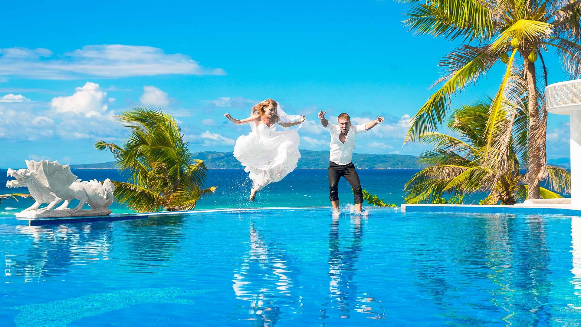 Couple de mariés se jetant à l'eau dans une piscine