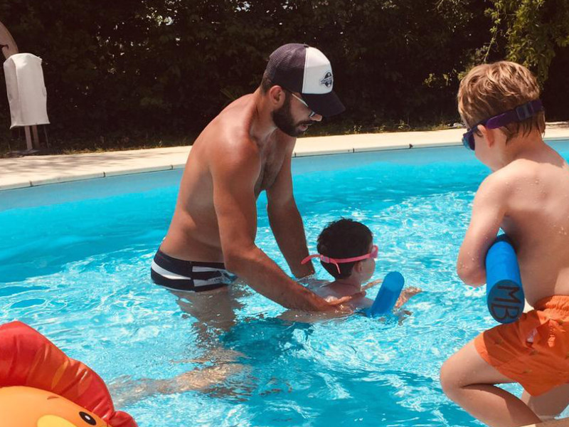 Maître-Baigneur en action apprenant à nager à deux enfants avec du matériel pédagogique